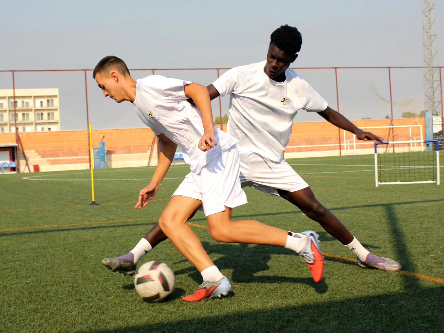 Dos futbolistas de JP Fútbol disputando el balón durante un entrenamiento